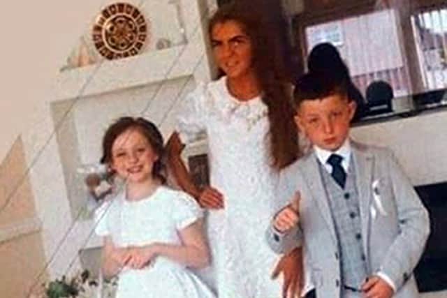 Dozens of bunches of flowers, teddy bears and candles have been placed along the wall as well as photographs of the three, showing Christy and Chelsea making their first Holy Communion.