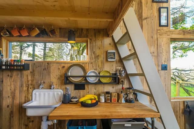 Behind the stairs is a kitchenette with a double ring induction hob, smaller than standard oven and grill and a compact fridge with a little icebox.