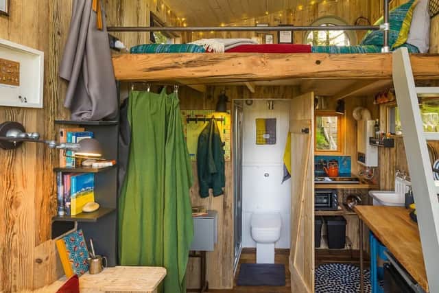At the back left corner of the treehouse is a small cubicle holding a flushing toilet and shower. The one sink in the treehouse is at the kitchen counter. Both the shower and sink have on demand hot water.
