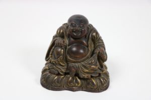 The 19th century Chinese carved wooden, seated, smiling Buddha, 18cms high made €13,000 at Fonsie Mealy's auction yesterday