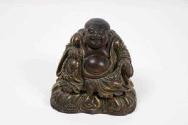The 19th century Chinese carved wooden, seated, smiling Buddha, 18cms high made €13,000 at Fonsie Mealy's auction yesterday