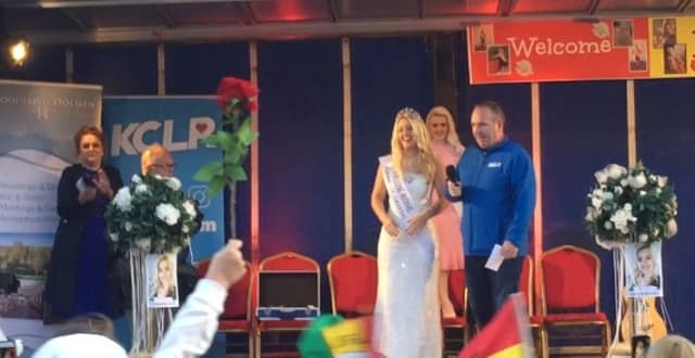 A rose is held aloft as Shauna Ray Lacey is on stage with MC, Brendan Hennessy