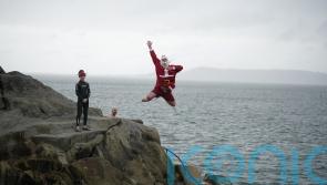 Crowds – including the ‘Forty Foot Santa’ – take part in Christmas Day swim