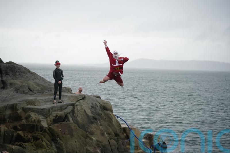 Crowds – including the ‘Forty Foot Santa’ – take part in Christmas Day swim